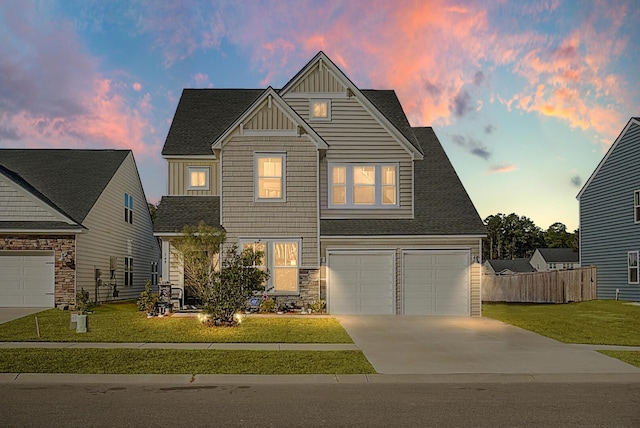 view of front of property featuring a garage and a lawn