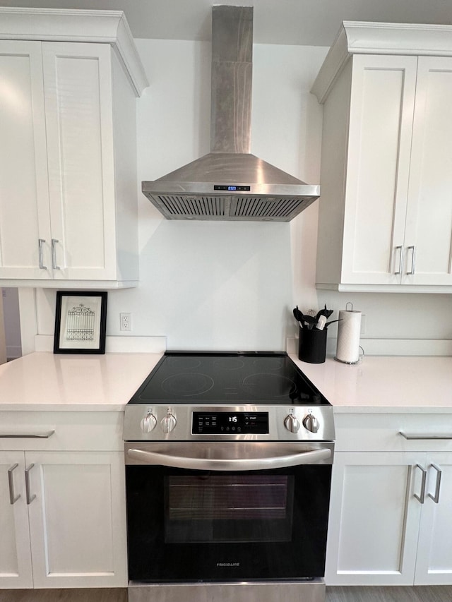 kitchen featuring extractor fan, white cabinets, and stainless steel electric range oven