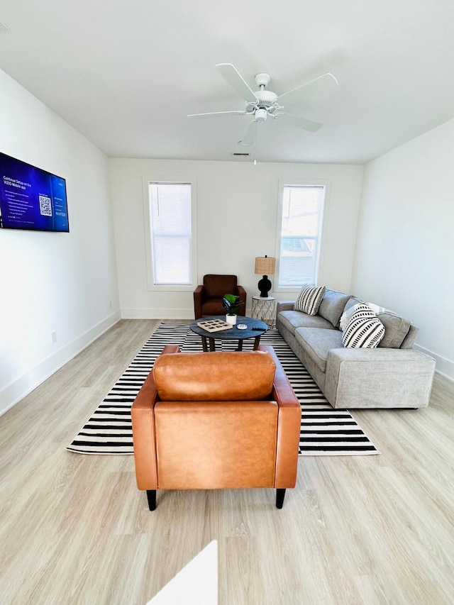 living room with light hardwood / wood-style flooring and ceiling fan