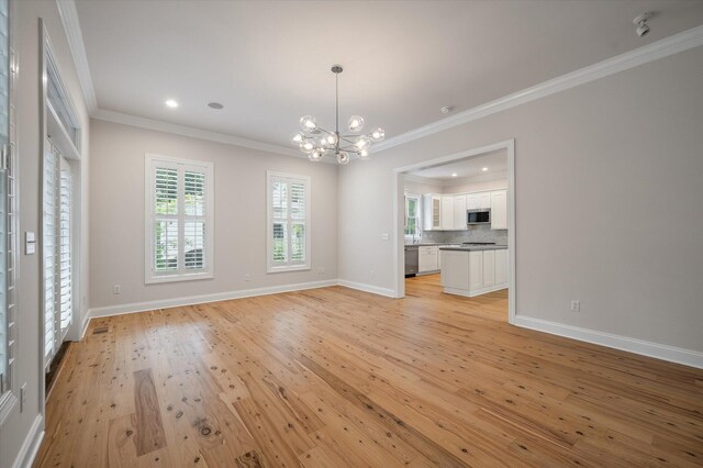 5152 Coral Reef Dr, Johns Island, SC 29455 - unfurnished living room with a chandelier, ornamental molding, light wood-style floors, and recessed lighting