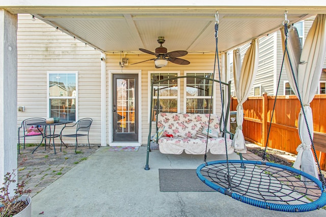 view of patio featuring ceiling fan and fence