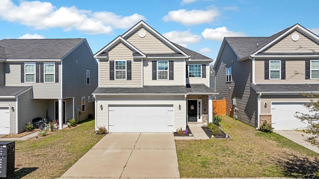 view of front of home with driveway, an attached garage, a front lawn, and a shingled roof