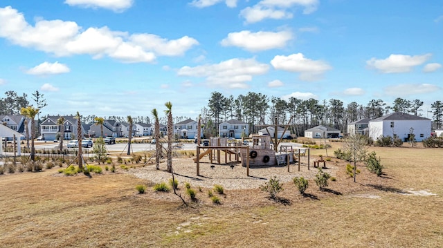 communal playground featuring a residential view and a yard