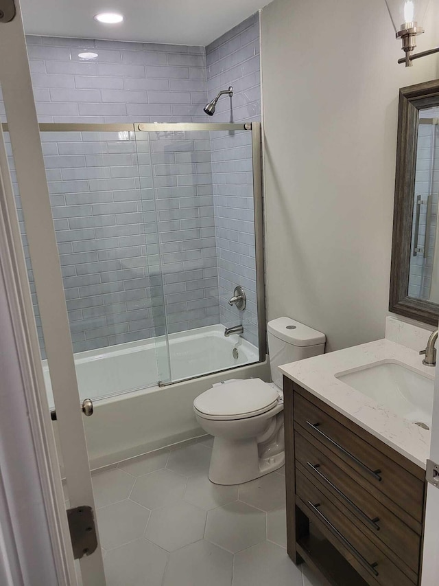 full bathroom featuring tile patterned flooring, vanity, bath / shower combo with glass door, and toilet