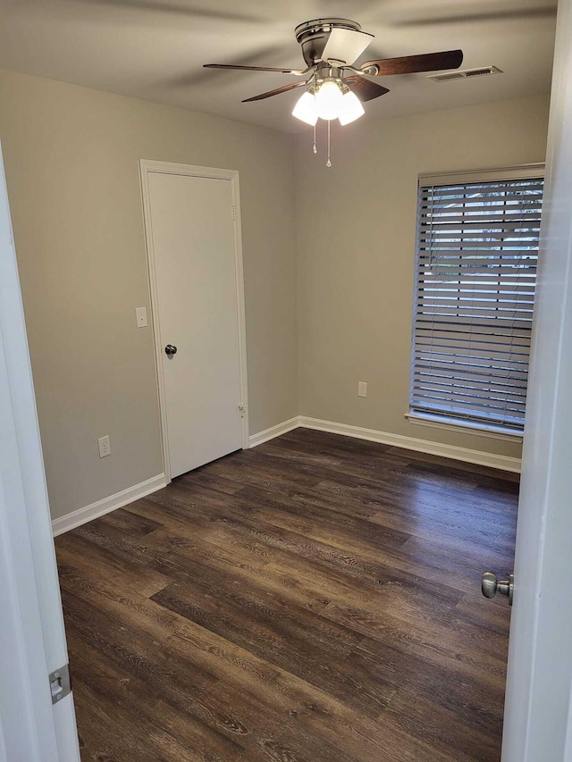 empty room featuring ceiling fan and dark hardwood / wood-style flooring