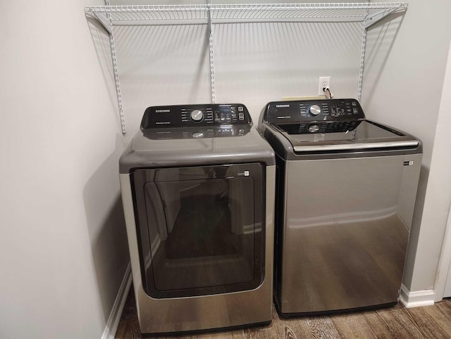 laundry area featuring washing machine and dryer and hardwood / wood-style flooring