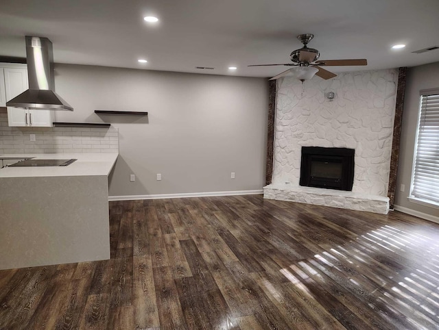 unfurnished living room with a fireplace, ceiling fan, and dark wood-type flooring