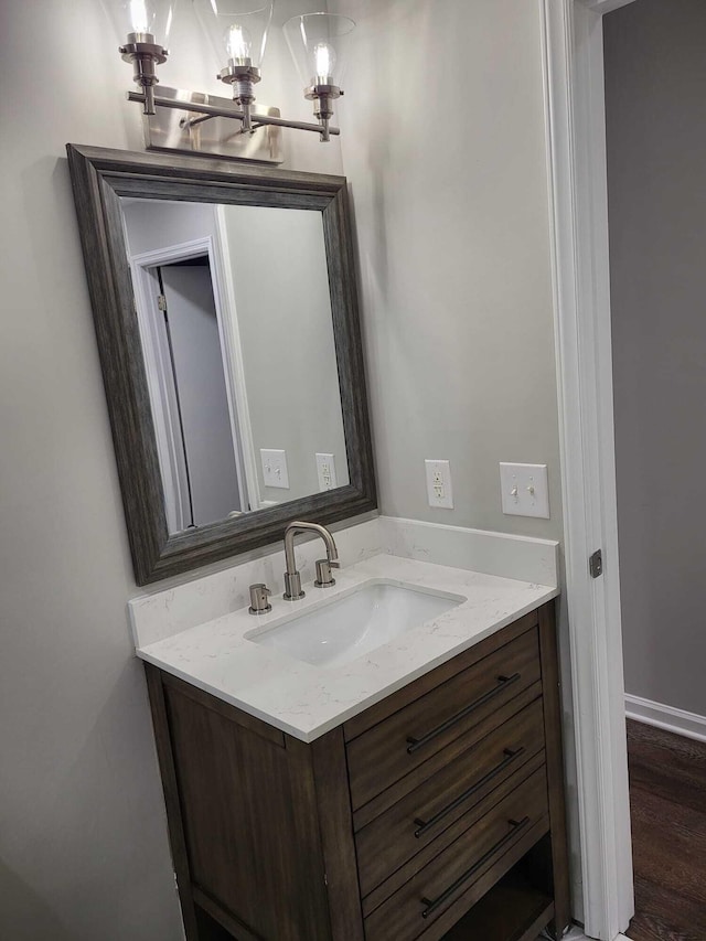 bathroom featuring wood-type flooring, vanity, and an inviting chandelier