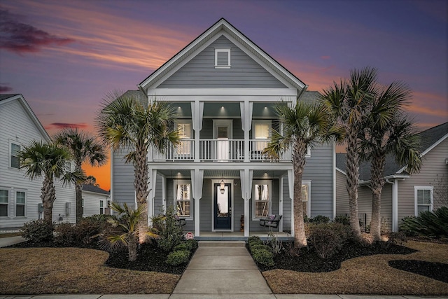 coastal inspired home featuring a balcony and covered porch