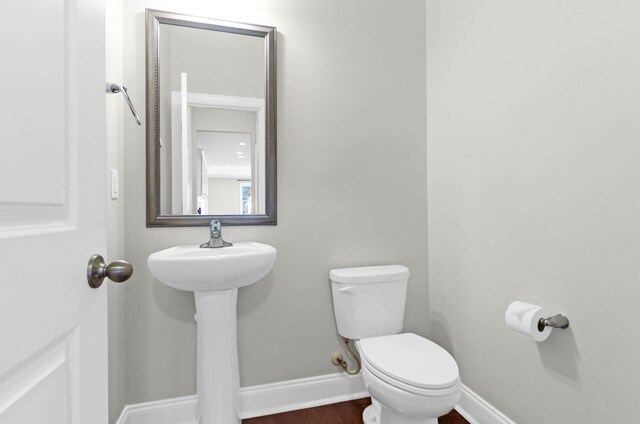 bathroom with hardwood / wood-style flooring, sink, and toilet