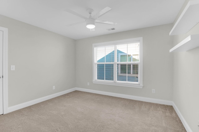 carpeted spare room featuring ceiling fan