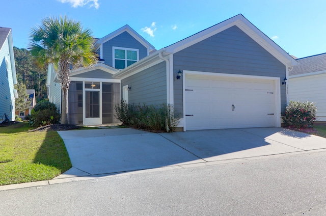 view of front of home featuring a sunroom, a garage, and a front lawn