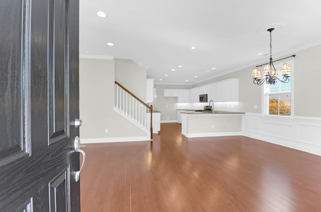 foyer with a chandelier, dark hardwood / wood-style floors, and crown molding