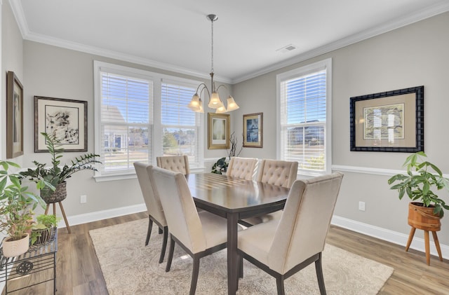 dining room with crown molding, a wealth of natural light, a chandelier, and hardwood / wood-style flooring