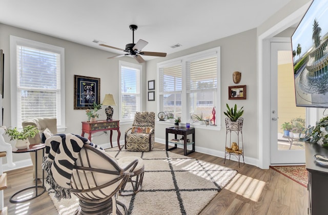 living area with hardwood / wood-style floors and ceiling fan