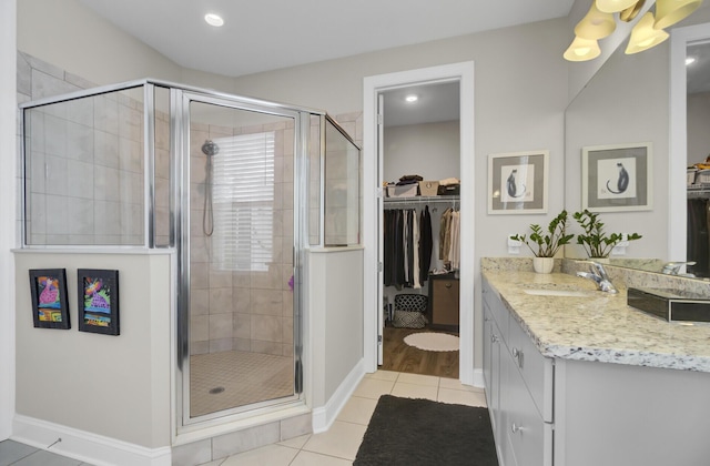 bathroom with tile patterned flooring, vanity, and a shower with shower door