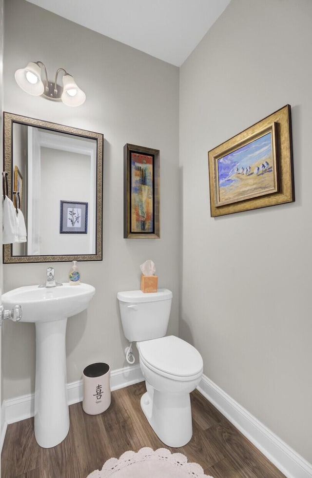 bathroom with hardwood / wood-style floors and toilet