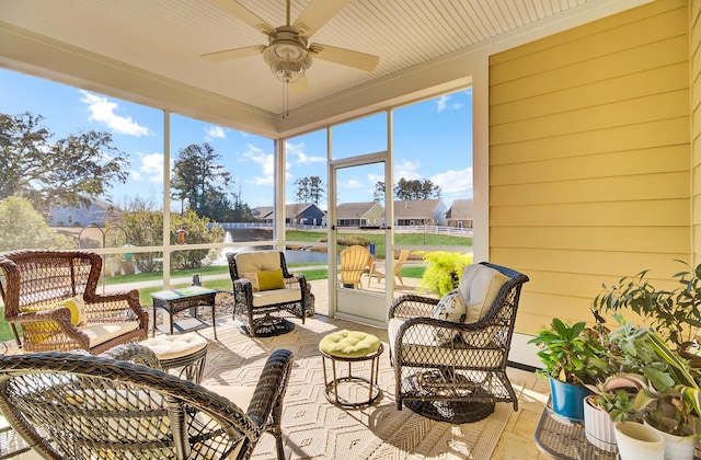 sunroom / solarium featuring a water view and ceiling fan