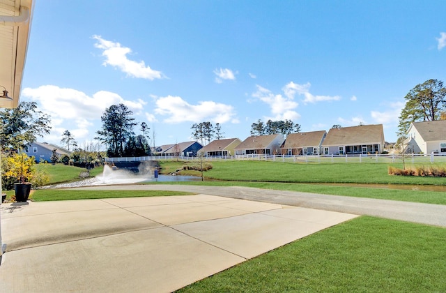 view of property's community featuring a water view and a yard