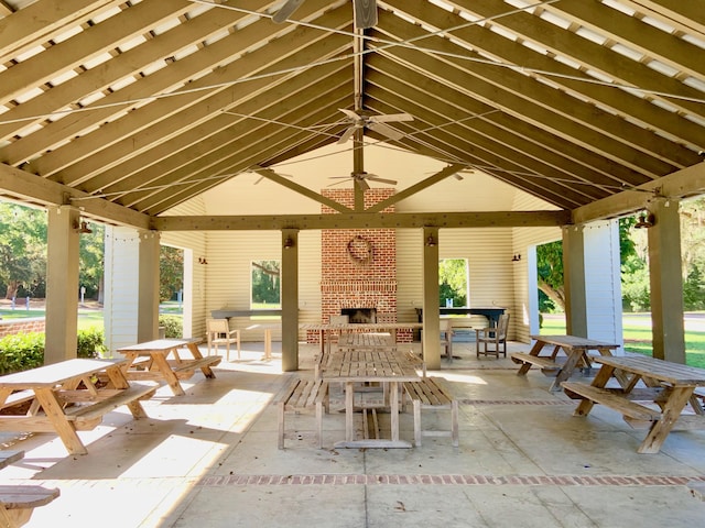 view of patio / terrace featuring an outdoor brick fireplace, a gazebo, and ceiling fan