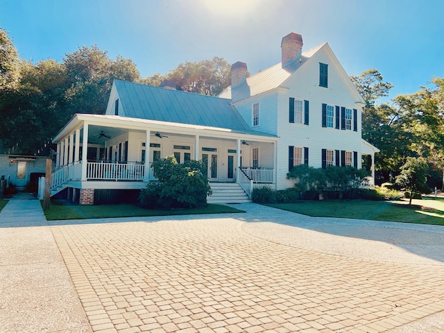 view of front of house featuring ceiling fan, covered porch, and a front lawn