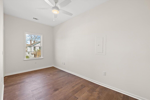 unfurnished room with baseboards, visible vents, dark wood-style floors, and ceiling fan