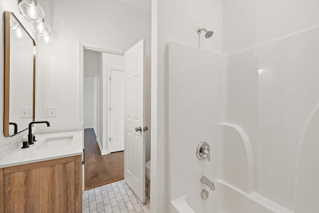 bathroom with shower / bath combination, vanity, and toilet