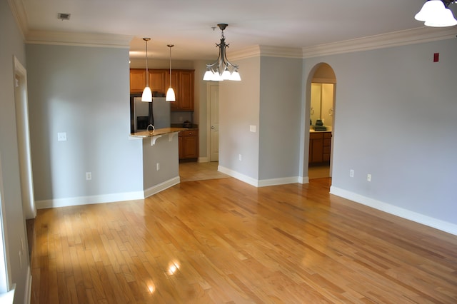 unfurnished living room featuring crown molding and light hardwood / wood-style flooring