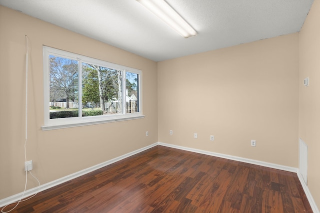 unfurnished room with dark wood-style floors and baseboards