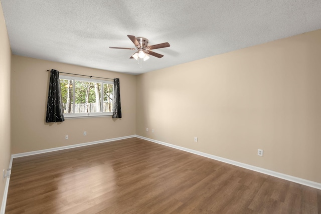 spare room with a textured ceiling, a ceiling fan, baseboards, and wood finished floors