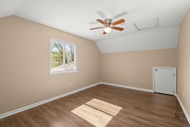 additional living space featuring vaulted ceiling, wood finished floors, and visible vents