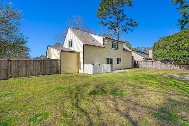 back of house with a lawn and a fenced backyard