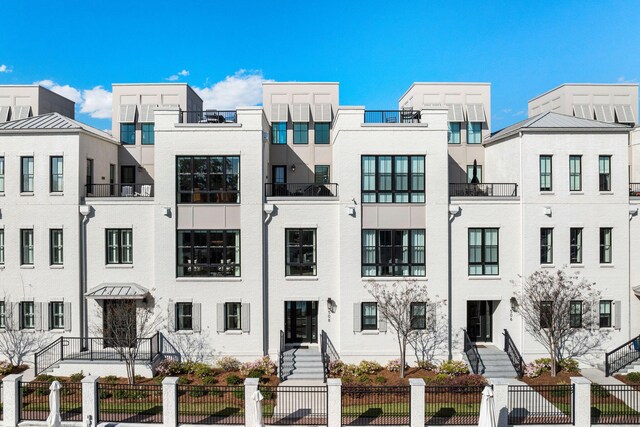 view of front of home featuring stucco siding and fence
