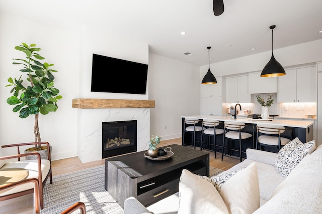 living room featuring recessed lighting, light wood finished floors, visible vents, and baseboards