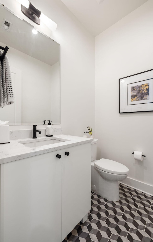 bathroom featuring tile patterned floors, vanity, visible vents, and toilet