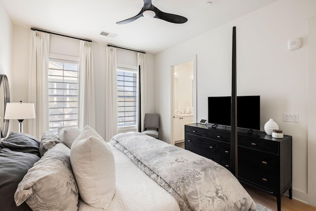 bedroom with wood finished floors, ceiling fan, baseboards, and visible vents