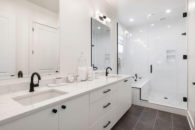 full bath with a sink, visible vents, double vanity, and a stall shower