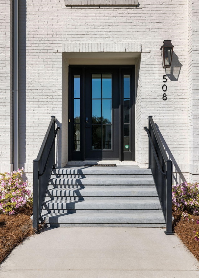 doorway to property featuring brick siding