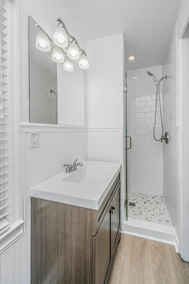 bathroom featuring hardwood / wood-style floors, walk in shower, and vanity