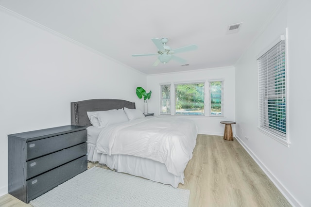 bedroom with ceiling fan, light wood-type flooring, and crown molding