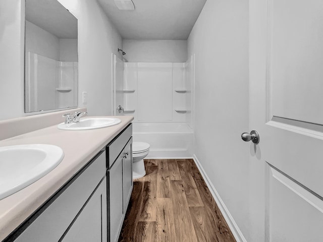 full bathroom featuring hardwood / wood-style flooring, vanity, toilet, and shower / washtub combination