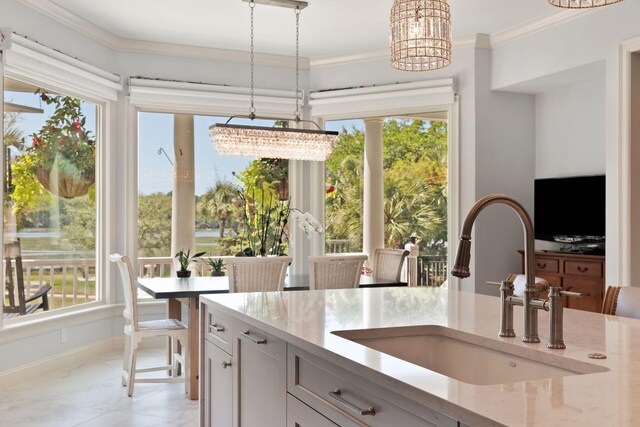 kitchen featuring decorative light fixtures, white cabinets, and a healthy amount of sunlight