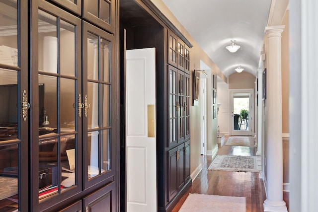 hallway featuring crown molding, dark wood-type flooring, and decorative columns