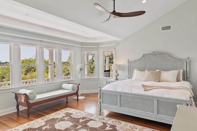 bedroom with multiple windows, dark hardwood / wood-style floors, and ceiling fan