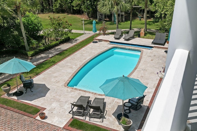 view of pool featuring a yard and a patio