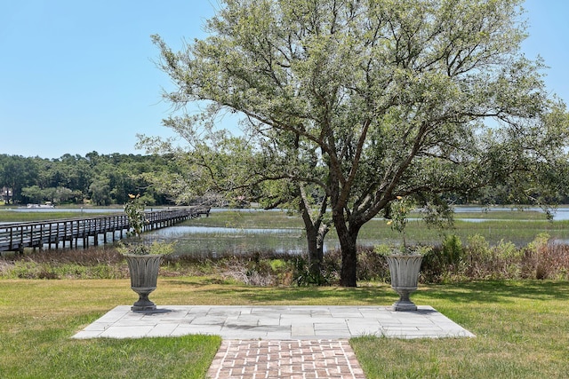 surrounding community with a lawn and a water view