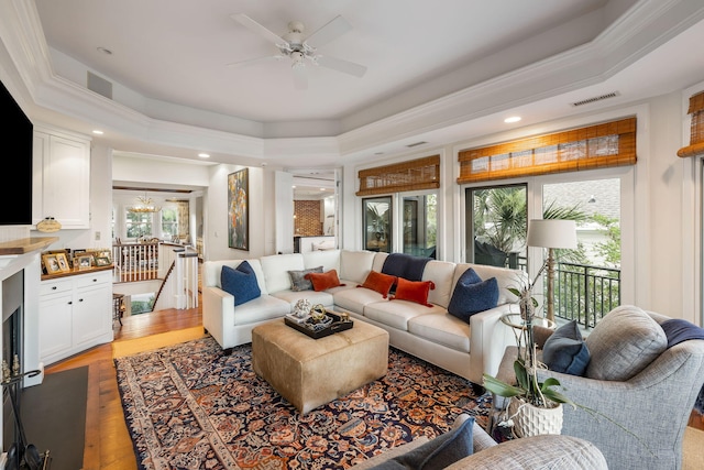 3121 Marshgate Dr, Seabrook Island, SC 29455 - living room featuring a tray ceiling, a ceiling fan, light wood-style floors, a chandelier, and recessed lighting