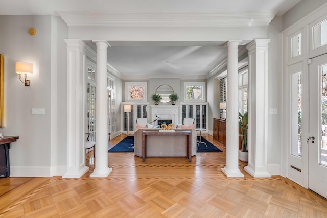 foyer entrance with a high end fireplace, decorative columns, and baseboards