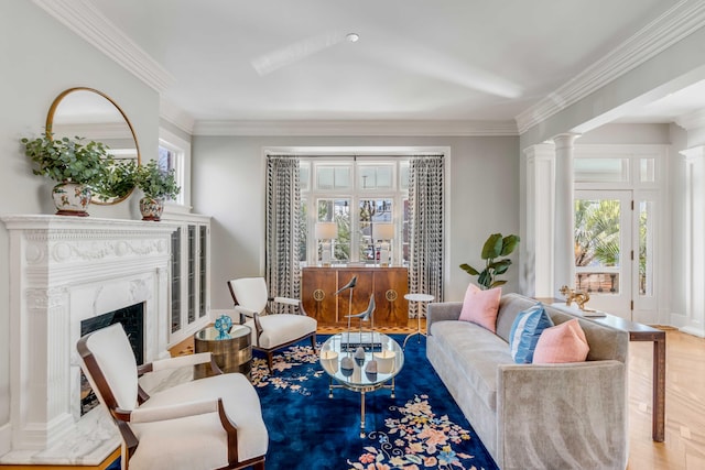 living area featuring ornamental molding, a premium fireplace, and ornate columns