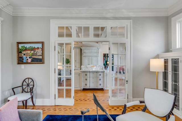 sitting room with baseboards and ornamental molding